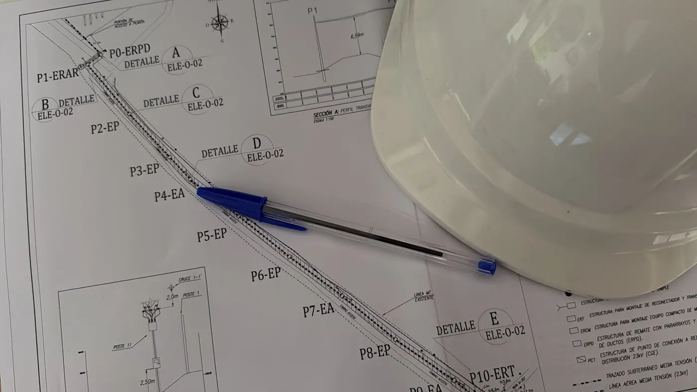 Plano de proyecto con bolígrafo y casco de obra